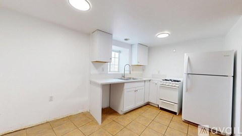 A kitchen with white appliances and cabinets.