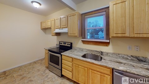 A kitchen with wooden cabinets and a marble countertop.