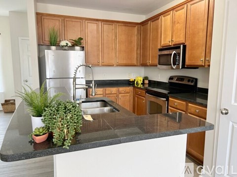 A kitchen with wooden cabinets and a black countertop.
