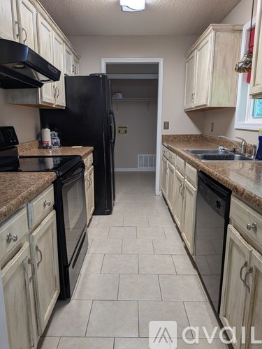 A kitchen with black appliances and white cabinets.