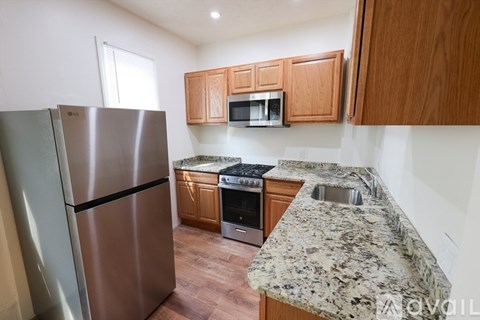 A kitchen with a granite counter top and stainless steel appliances.