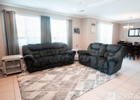 A living room with a grey sofa and a grey rug.