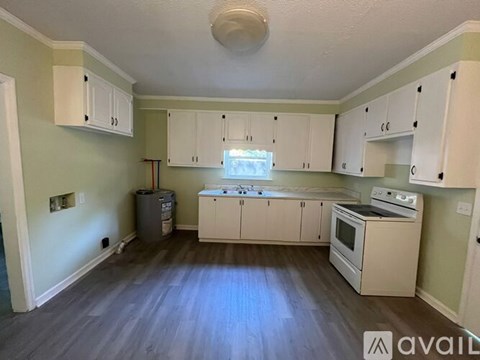 A kitchen with white cabinets and a stove top oven.