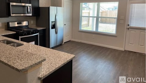 A kitchen with granite countertops and a refrigerator.
