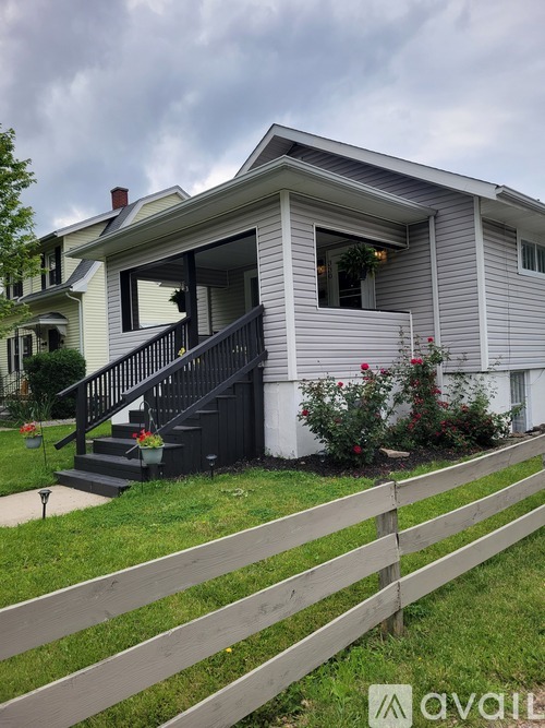 A house with a grey siding and a black front door.