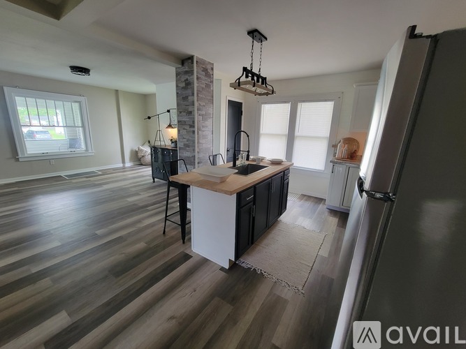 A kitchen with a wooden island and a refrigerator.