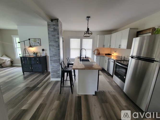 A modern kitchen with a wooden floor and stainless steel appliances.