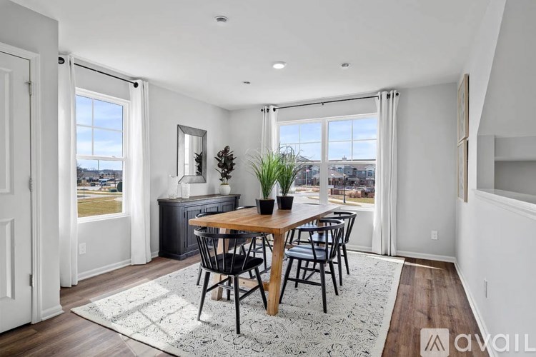 A dining room with a wooden table and chairs.