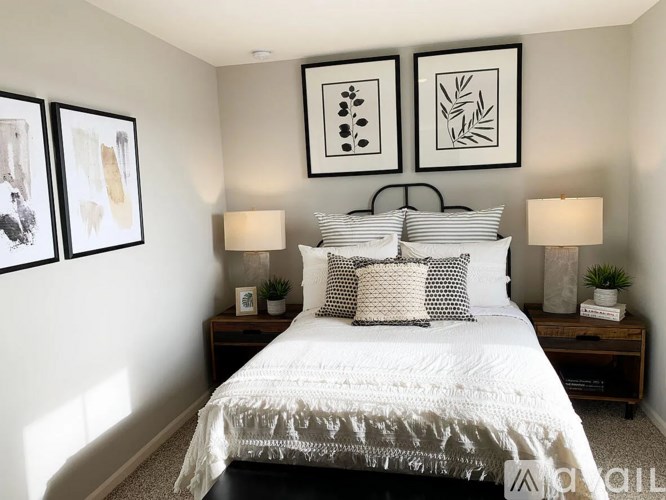 A bedroom with a white bed and two nightstands with lamps.