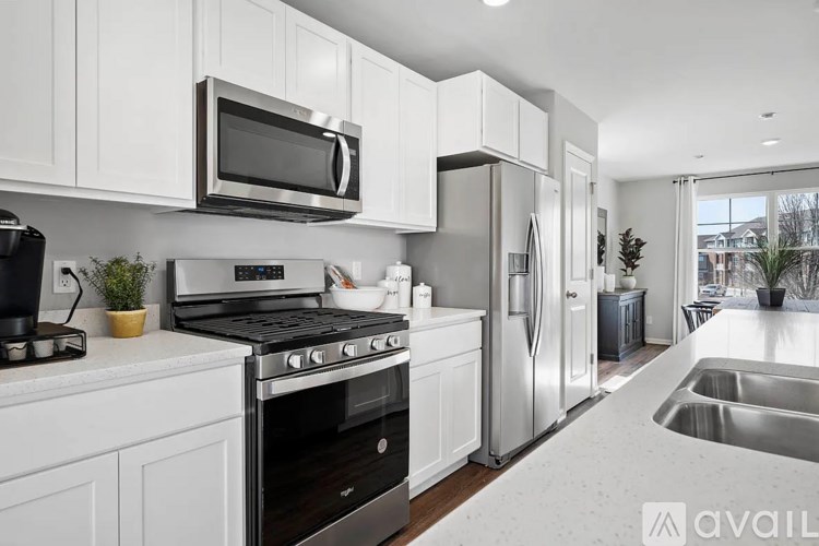 A modern kitchen with white cabinets and stainless steel appliances.