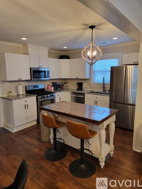 A kitchen with a wooden table and chairs.