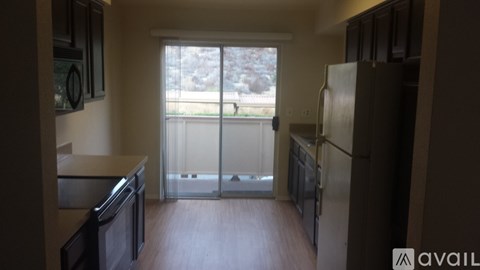 A kitchen with a refrigerator, microwave, and oven.