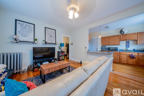A living room with a white couch and a television.