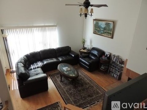 A black leather couch and ottoman are in a living room.
