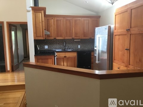 A kitchen with wooden cabinets and a black granite countertop.