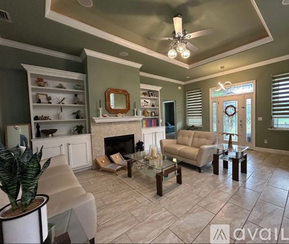 A living room with a fireplace, a couch, and a potted plant.
