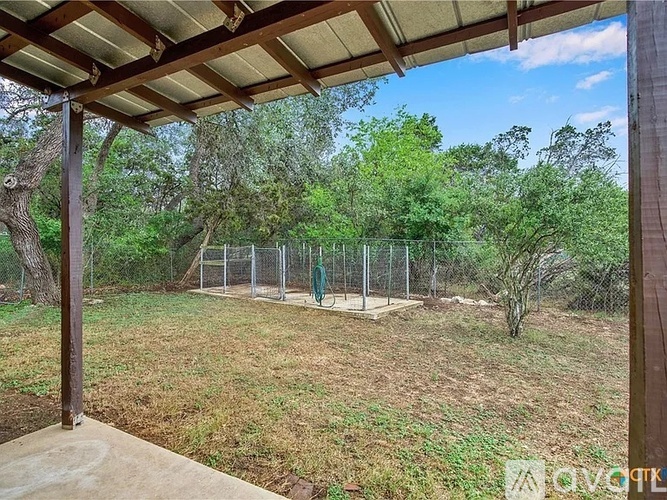 A backyard with a swing set and trees.