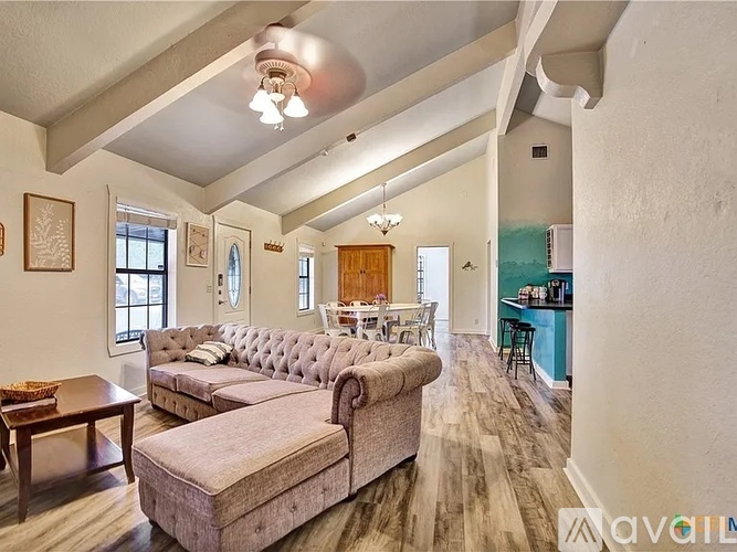 A living room with a grey couch and a wooden coffee table.
