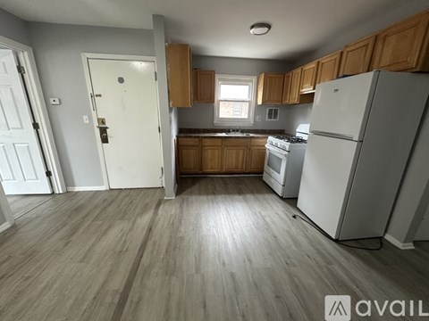 A kitchen with wooden cabinets and a white fridge.