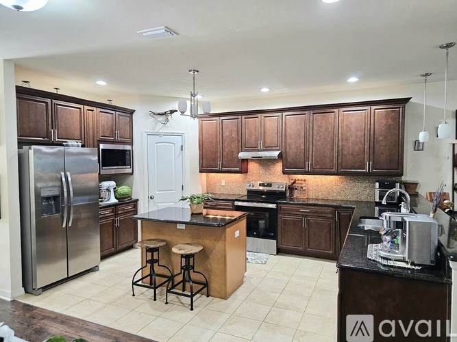 A kitchen with brown cabinets and a black countertop.
