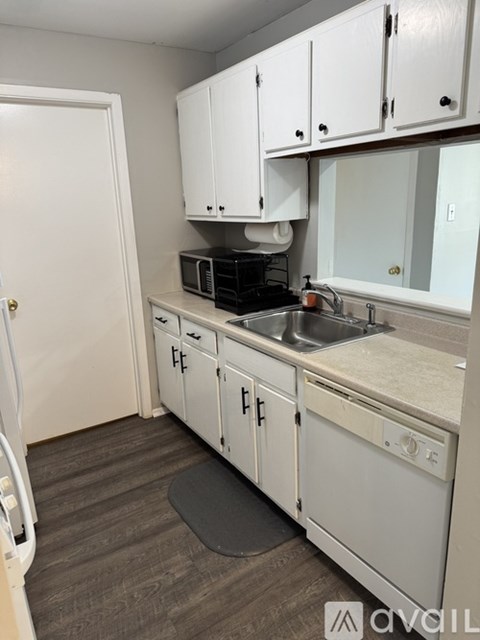 A kitchen with white cabinets and a sink.