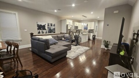A living room with a grey couch and a wooden floor.