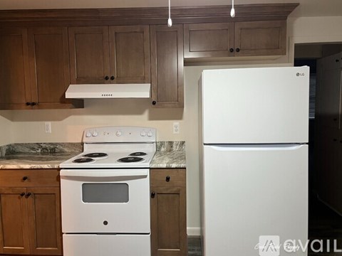 A kitchen with a white stove and refrigerator.