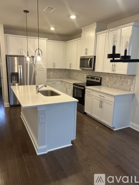 A kitchen with white cabinets and a black stove top oven.
