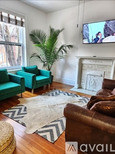 A living room with a green couch and a brown chair.