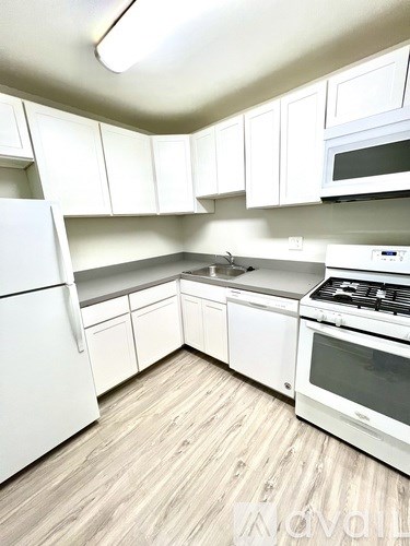 A kitchen with white appliances and cabinets.