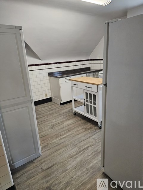 A kitchen with a grey floor and white appliances.