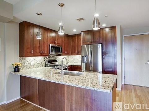 A kitchen with wooden cabinets and granite countertops.