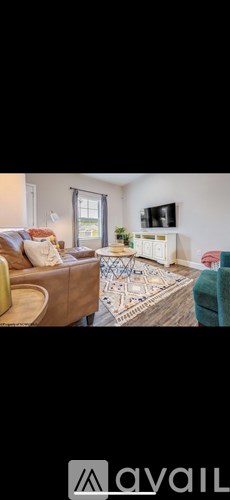 A living room with a brown leather couch and a white rug.