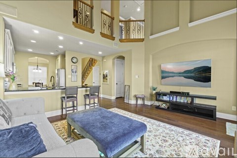 A living room with a grey couch and a blue ottoman.