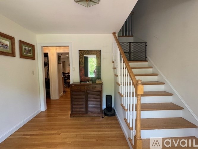A staircase with a wooden banister and a black metal railing.