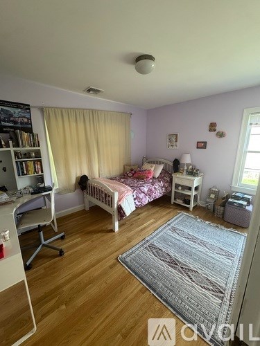 A bedroom with a bed, desk, and chair.