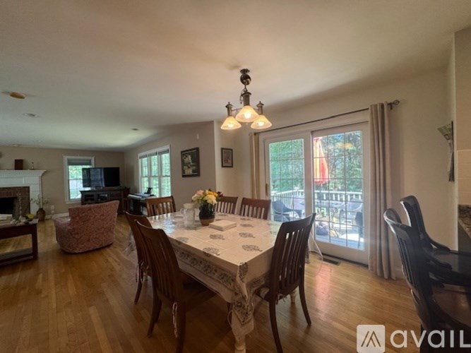 A dining room with a table set for six and a chandelier hanging from the ceiling.