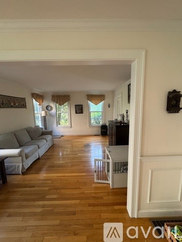 A living room with a grey couch and wooden floors.