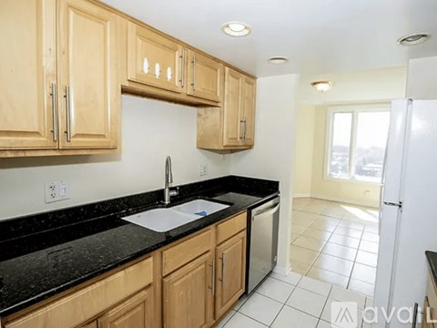 A kitchen with wooden cabinets and black countertops.