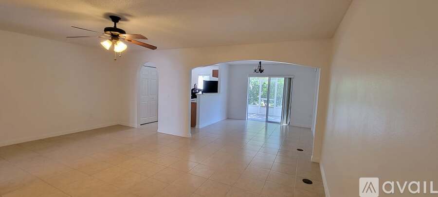 A spacious room with a ceiling fan and tiled flooring.