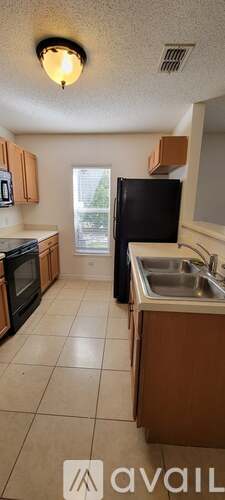 A kitchen with wooden cabinets and black appliances.
