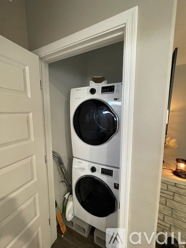 A white washing machine is in a small doorway.