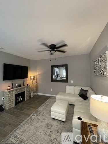 A living room with a white couch and a fireplace.