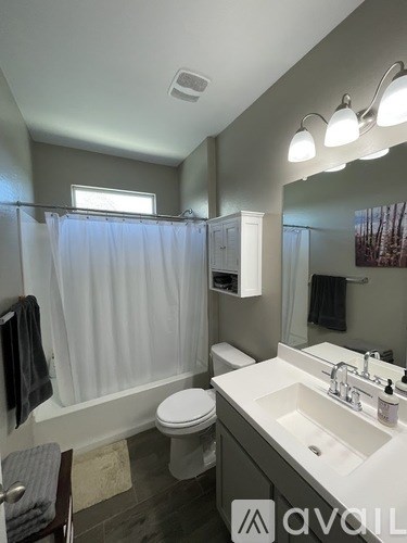 A bathroom with a toilet, sink, and shower.