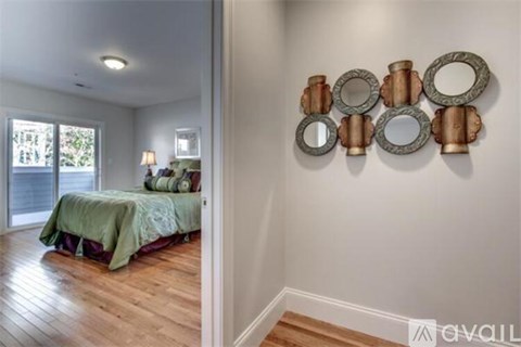 A bedroom with a bed and a mirror on the wall.