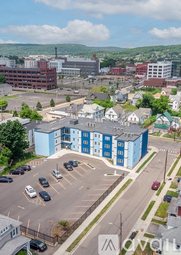 A parking lot with cars and a blue building in the foreground.