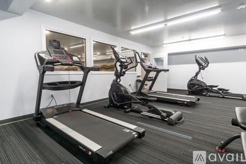A gym with treadmills, elliptical machines, and stationary bikes.