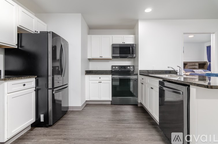 A kitchen with black appliances and white cabinets.