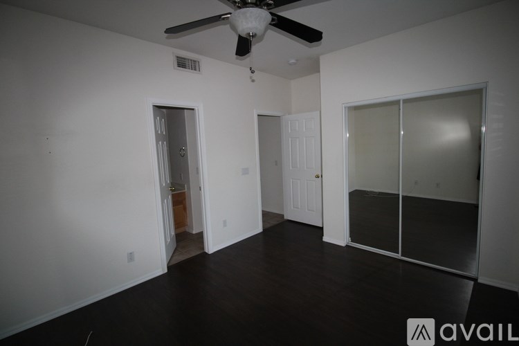 A room with a ceiling fan and a sliding glass door.