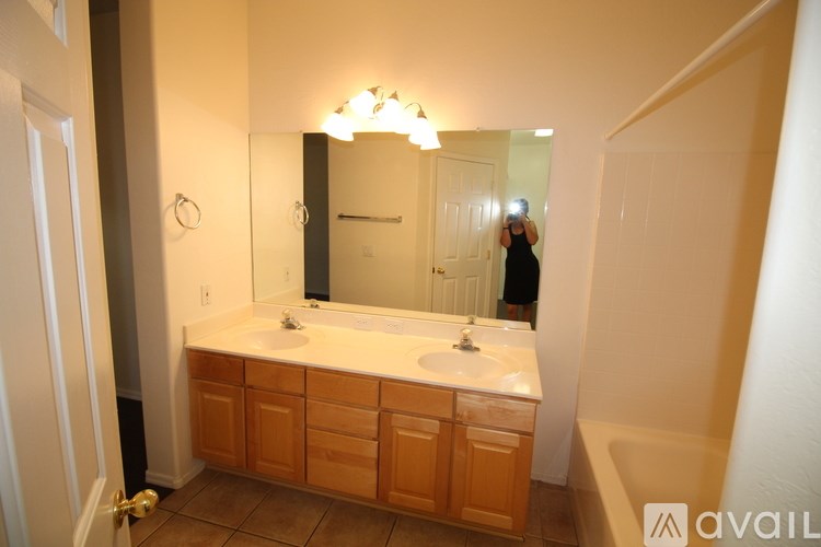 A bathroom with a sink, mirror, and wooden cabinets.